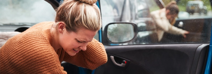 A woman holding her neck after a car accident.