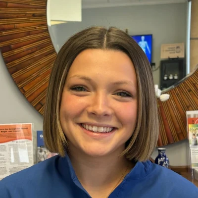 Intern Ava Leonard smiles warmly at the viewer in the office