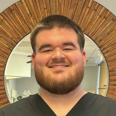 Staff Member Chance Bolin Smiling In Office