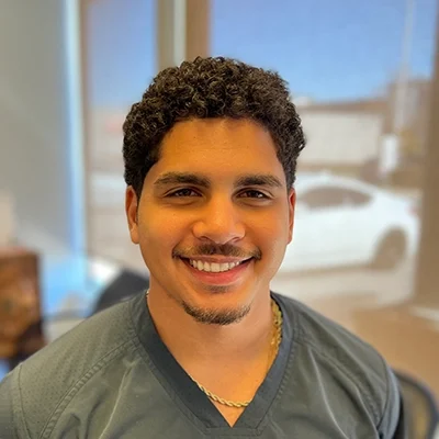 Staff Member Braylon Velasquez Smiling In Office