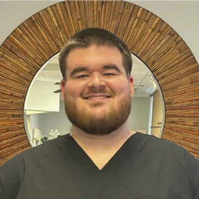 Staff Member Chance Bolin Smiling In Office